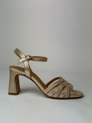 a close up of a pair of gold sandals on a white background