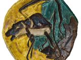 une photo d'une sculpture en céramique représentant un cheval, posée sur une assiette jaune et verte