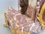a statue of a man sitting on top of a marble bench