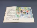 un livre ouvert sur lequel figure le dessin d'un groupe de personnes assises autour d'une table