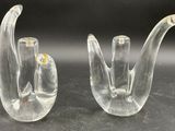 pair of clear glass hand sculptures on a black surface