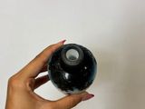 a woman holding a black ball in her hand