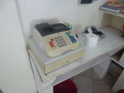 une caisse enregistreuse posée sur un bureau blanc