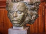 un buste en bronze représentant un homme, posé sur une table en bois