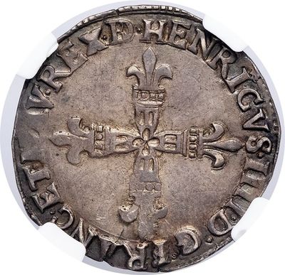 a close up of a silver coin with a cross on it