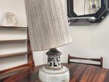 a table with a lamp on it and a mirror in the background