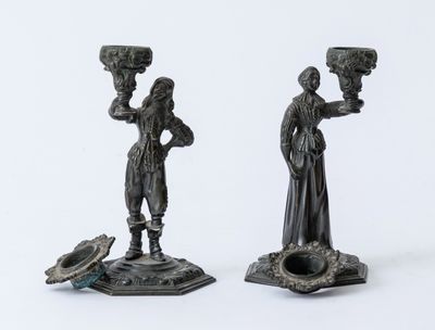 pair of bronze figurines of a woman and a man holding a bird