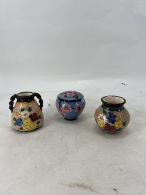 three small vases sitting on top of a white surface