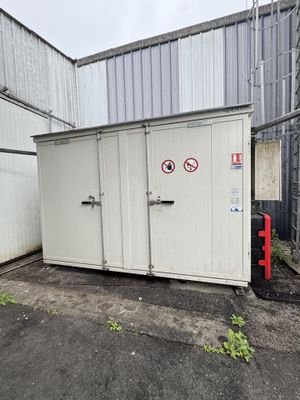 un conteneur de stockage blanc posé au milieu d'un parking