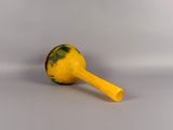 a yellow toy with a yellow handle on a white surface