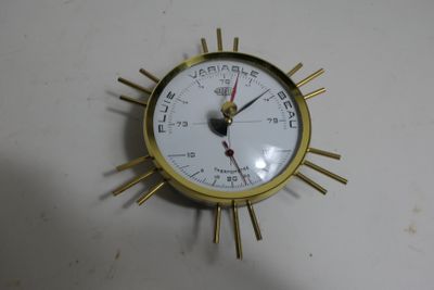 a gold clock with a white face on a white table