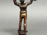 bronze figurine of a man holding a baseball glove and ball