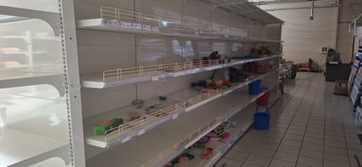 de nombreuses étagères vides dans un magasin où se trouvent des articles