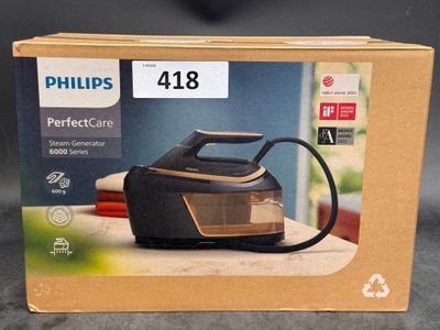 packaging of a black and gold steam iron on a table