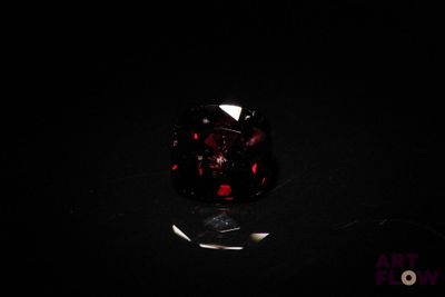 a close up of a red and black ring on a black surface