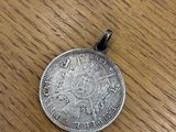 a close up of a silver coin on a wooden table