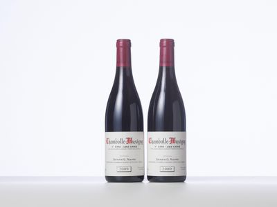 two bottles of red wine sitting on top of a table
