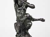 l'image d'une statue d'un homme assis sur un rocher