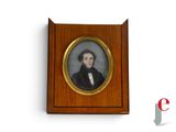 portrait d'un homme vêtu d'un manteau noir et d'une chemise blanche, dans un cadre en bois