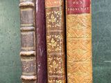 trois vieux livres posés l'un sur l'autre sur une table