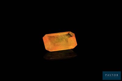 a yellow quartz stone on a black surface