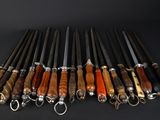 a bunch of knives are lined up in a row on a black surface