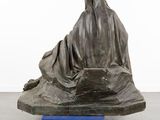 statue of a woman sitting on top of a cart with a sheet on it