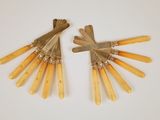 une paire d'ustensiles vintage à manche en bois posés sur une surface blanche