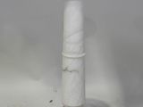 un bougeoir en marbre blanc posé sur une table blanche