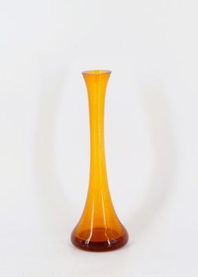 vase en verre jaune avec un socle marron sur fond blanc