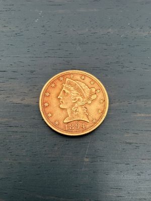 une pièce d'or posée sur une table, sur fond noir