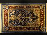 a close up of a rug on a black surface with fringes