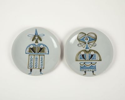 two plates with designs on them on a white surface