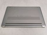 the back of a laptop with a silver cover on a white surface