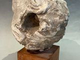 an image of a sculpture of a skull on a wooden block