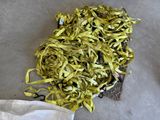 a pile of yellow ribbon on the floor next to a pair of scissors