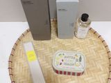 un petit plateau sur lequel se trouvent un flacon de parfum, une boîte de savon et une boîte de lotion