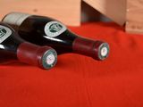 two bottles of wine sitting on a red cloth