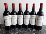 six bouteilles de vin sont alignées sur une table
