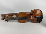 an old violin sitting on top of a table next to a glass of wine