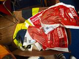 une boîte en carton remplie de gants et des gants par terre