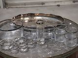 bottles and glasses on a silver tray on a table in a room