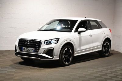 Le SUV Audi blanc est garé dans une pièce blanche.