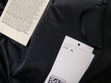 the back of a black jacket with a tag attached to it