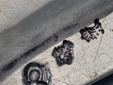 a close up of a silver plate with a knife on it