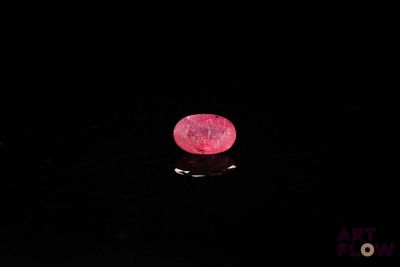 gros plan d'un diamant rose sur une surface noire