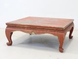 a small wooden table with a red top on a white floor