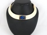 a close up of a necklace on a mannequin with a blue stone