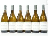 six bouteilles de vin sont alignées sur une surface blanche