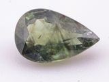 a close up of a green tourmaline gemstone on a white surface